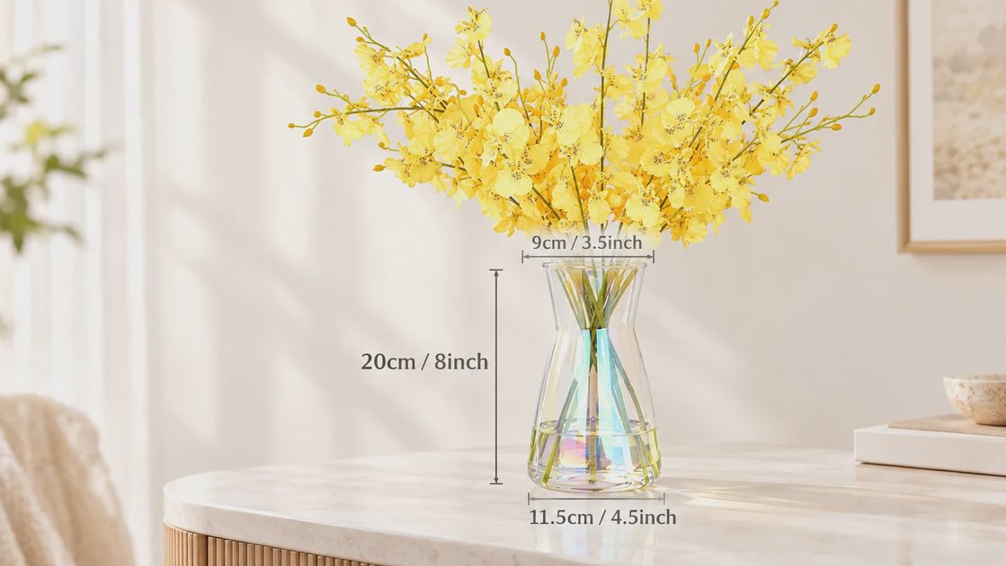 An iridescent glass vase filled with yellow dancing lady orchids sits on a marble table, marked with dimension lines for height and diameter.